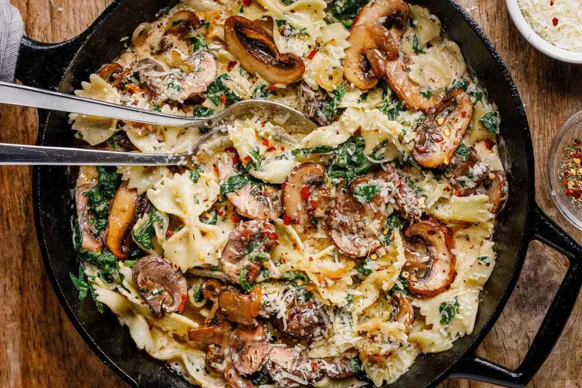 Farfallepasta med krämiga champinjoner, spenat och en touch av chili. En härlig pasta med creme fraiche som ser otroligt god ut.