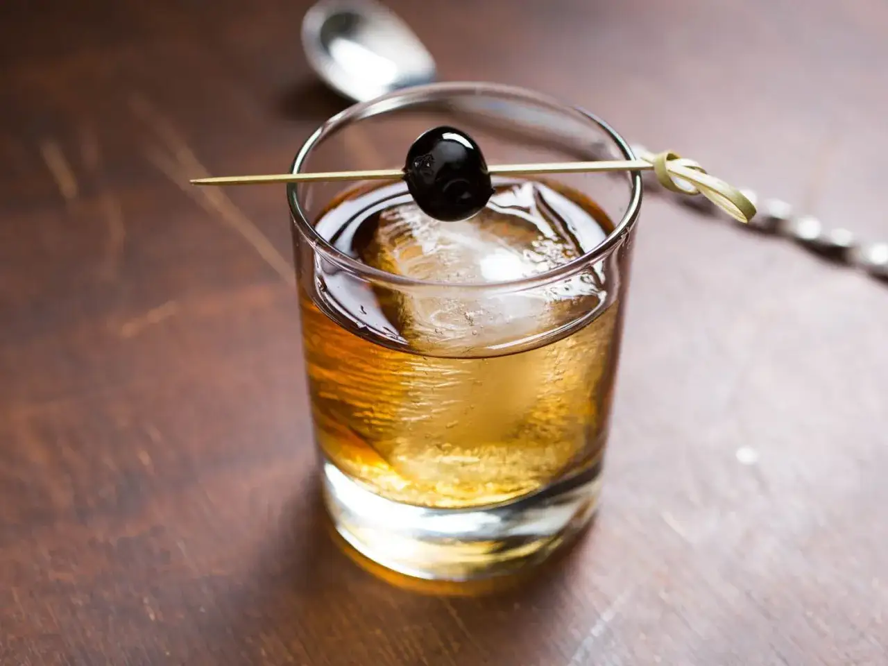 En klassisk manhattan drink med is och körsbär, redo att avnjutas.