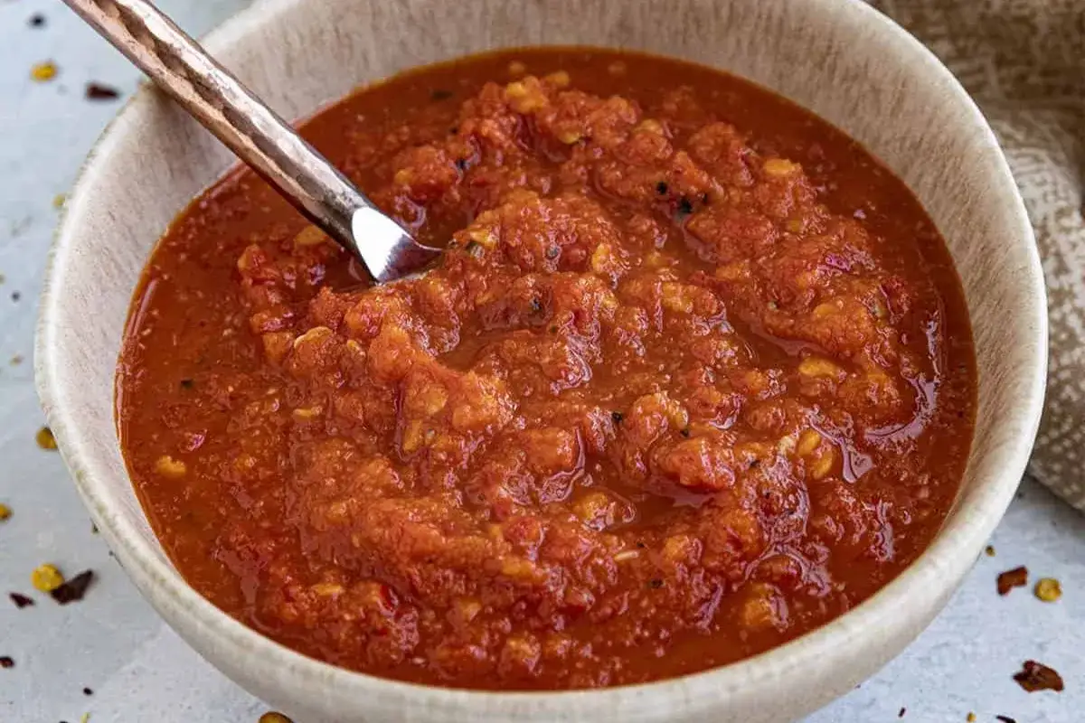 En skål med härlig, chunky sweet chili sås med en sked i. Perfekt till vårrullar eller som dipp.