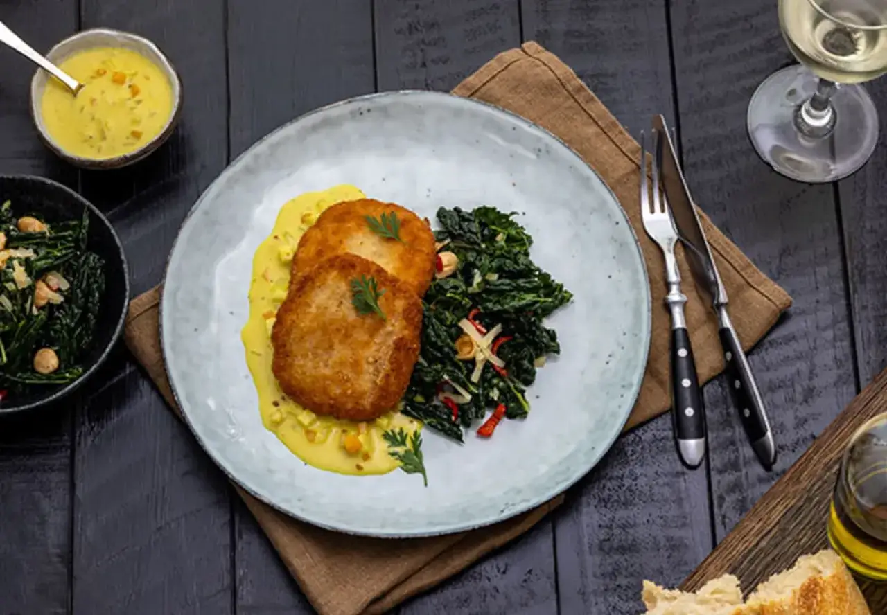 Tv&aring; gyllene fiskkakor med kr&auml;mig currys&aring;s och gr&ouml;nk&aring;l. Ett perfekt currys&aring;s recept f&ouml;r en smakrik middag.