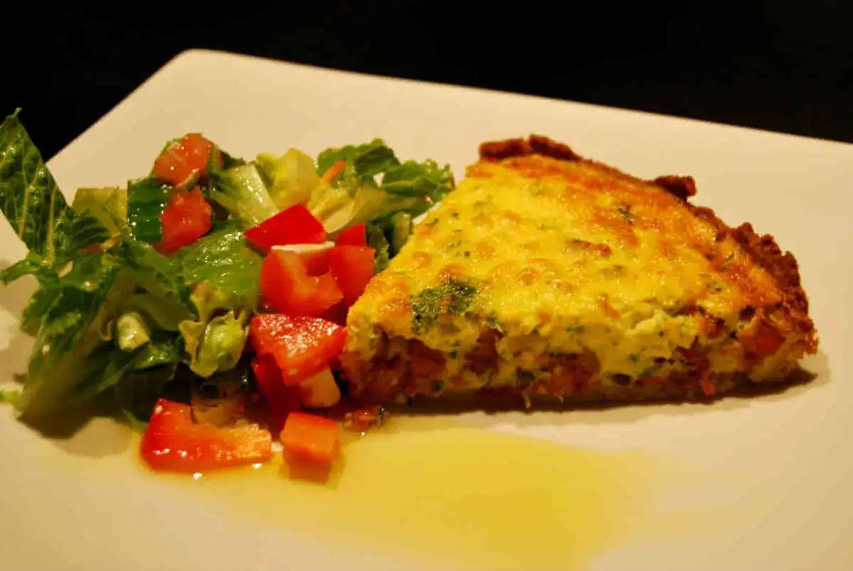 En bit kycklingpaj med bacon och en fräsch sallad med tomater och gurka.