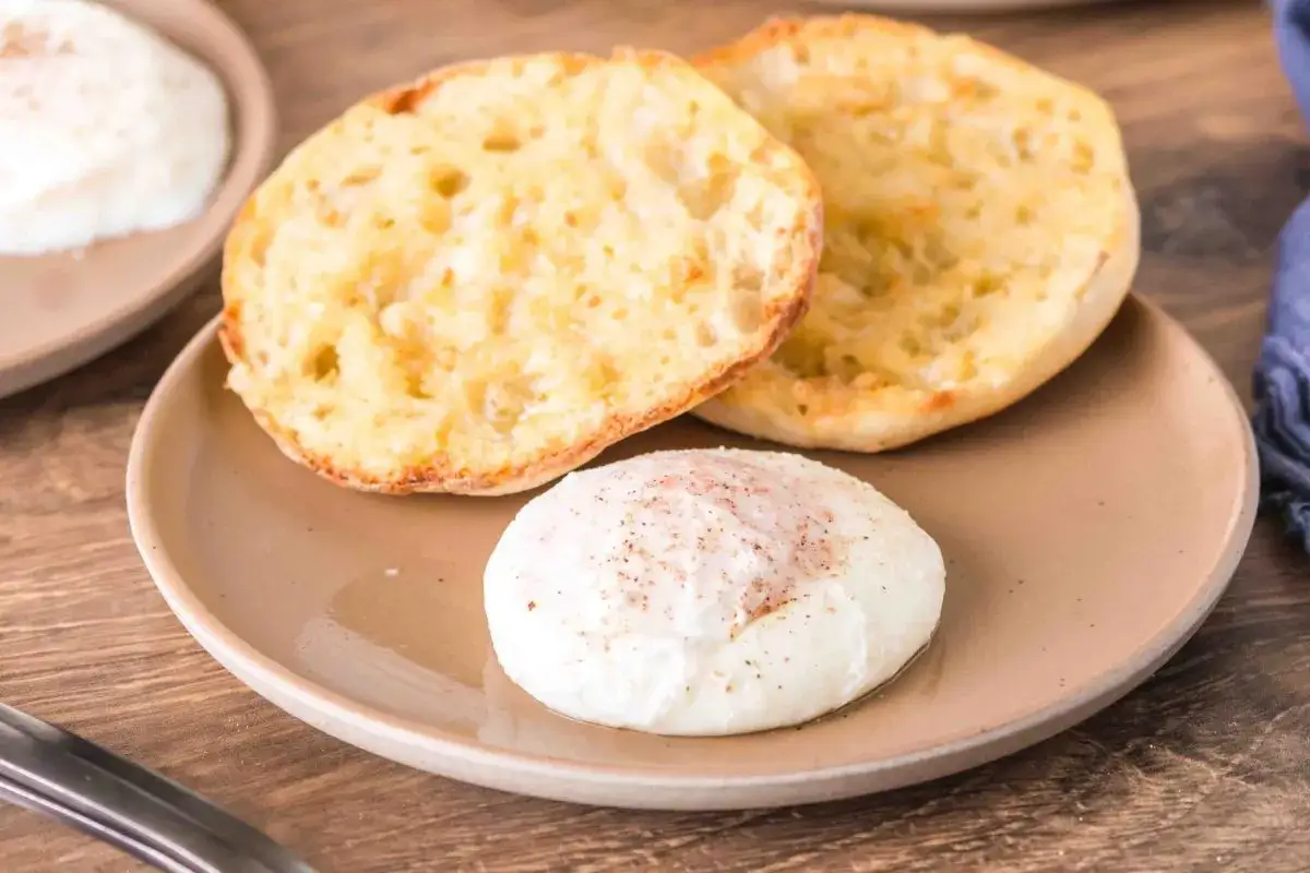 En rostad engelsk muffin med ett pocherat ägg, kryddat med peppar.