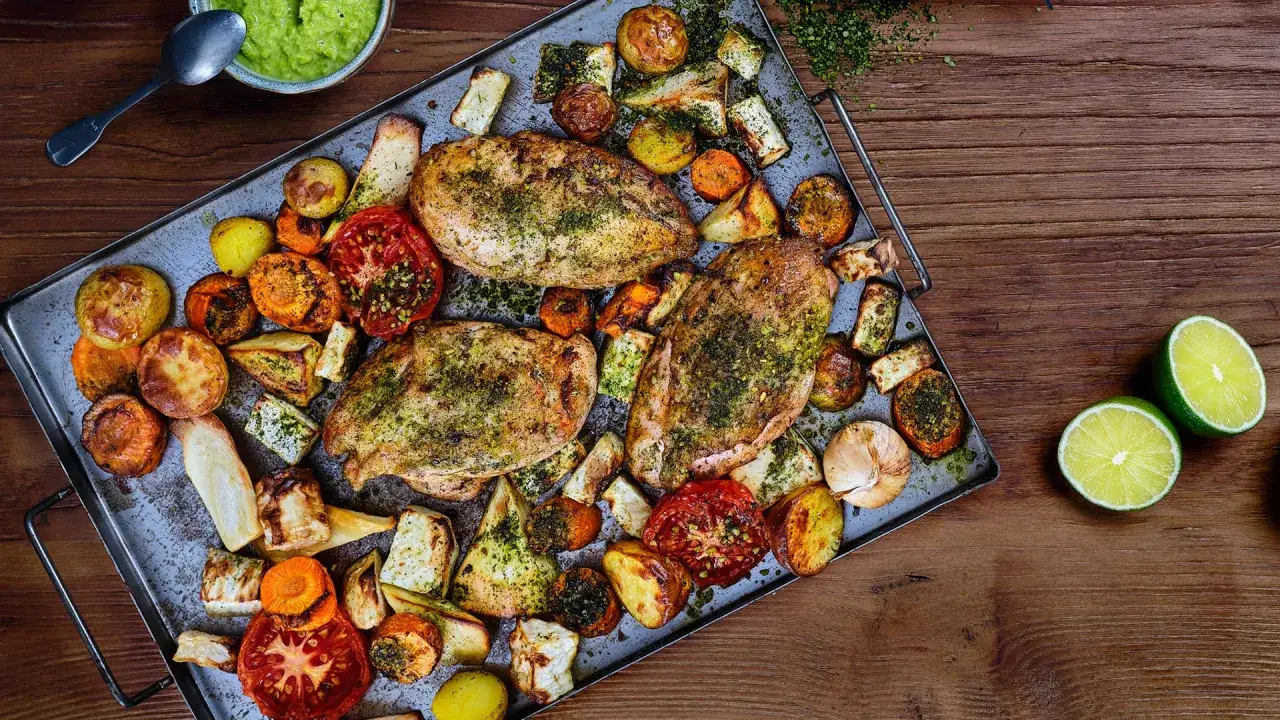 Ugnsbakade kycklingklubbor med rotfrukter, tomater och vitlök. En härlig och smakrik måltid.