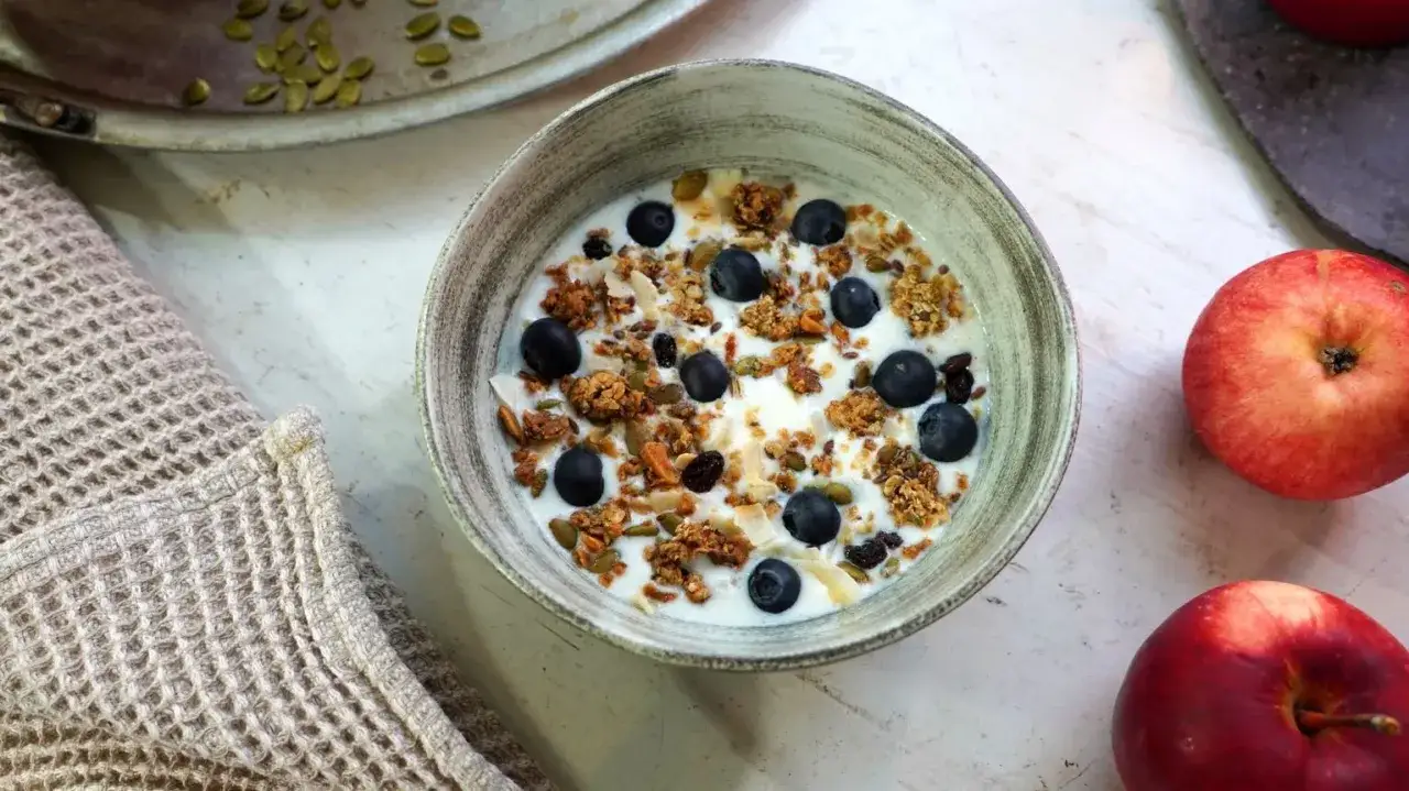 En skål med yoghurt, blåbär, nötter och frön. Perfekt för ett snabbt och gott granola recept.