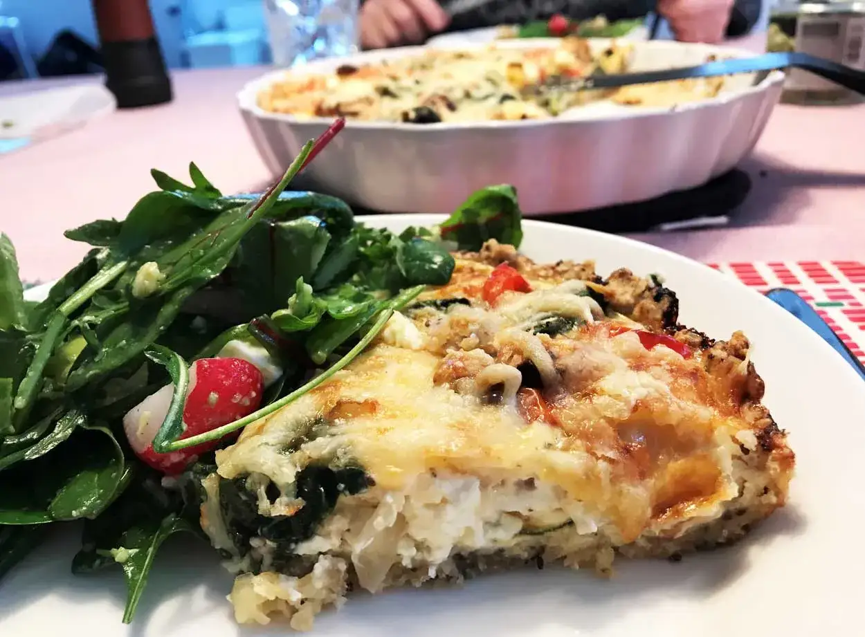 En bit gyllene vegetarisk paj med en fräsch sallad. En härlig måltid som ser utsökt ut.