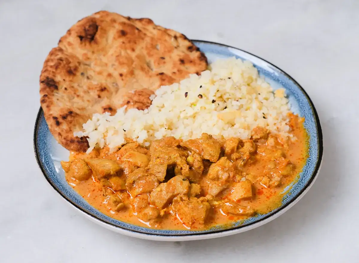 En portion kyckling tikka masala med ris och naanbröd. Ett perfekt tikka masala recept för en smakrik middag.