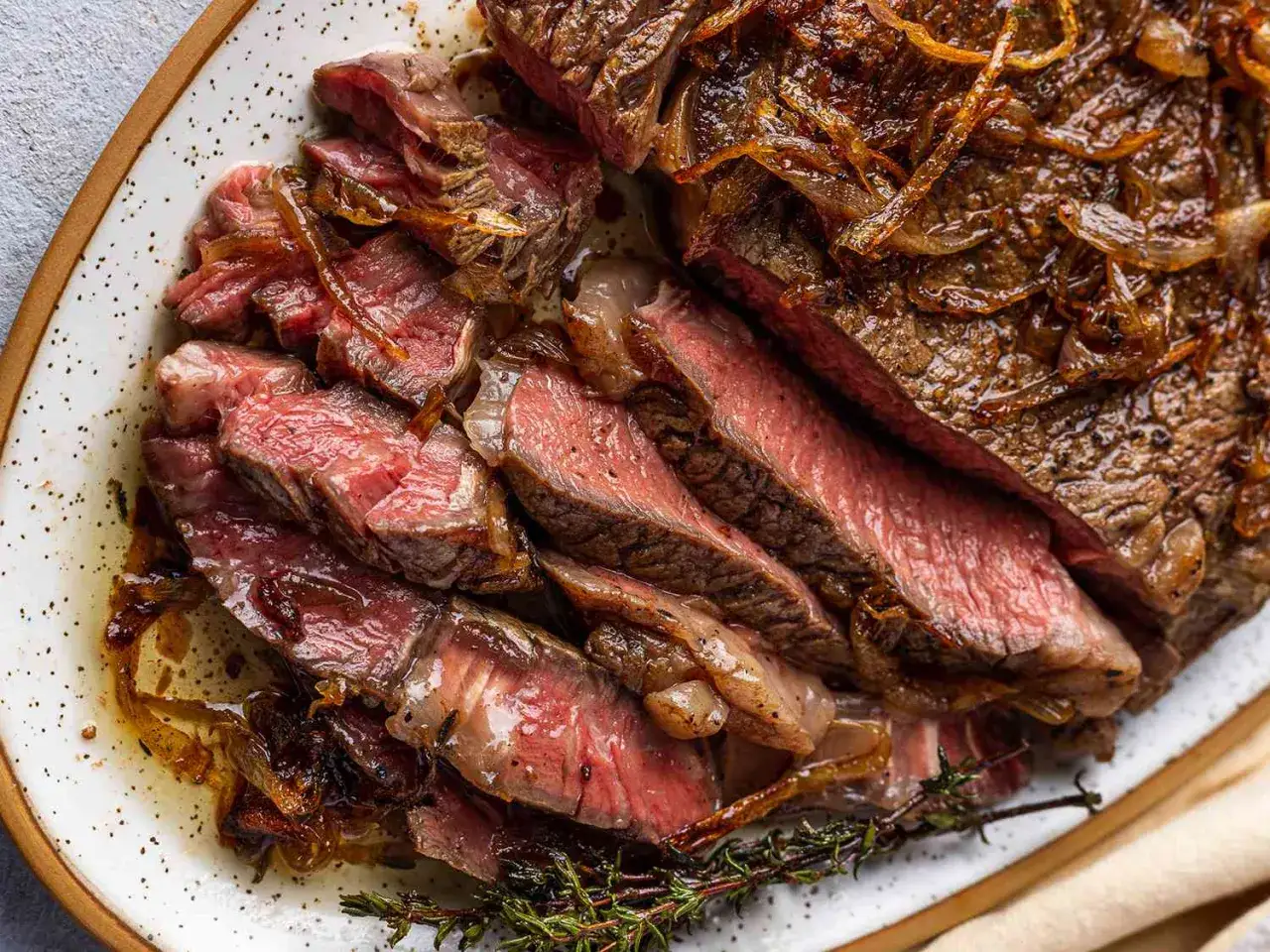 Perfekt stekt entrecote, skivad och serverad med karamelliserad lök och färsk timjan. En dröm att steka!