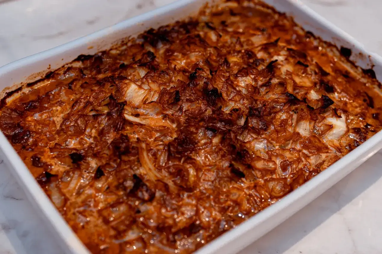 En gyllene kålpudding i en vit ugnsform, redo att serveras. Ett klassiskt kålpudding recept som doftar ljuvligt.