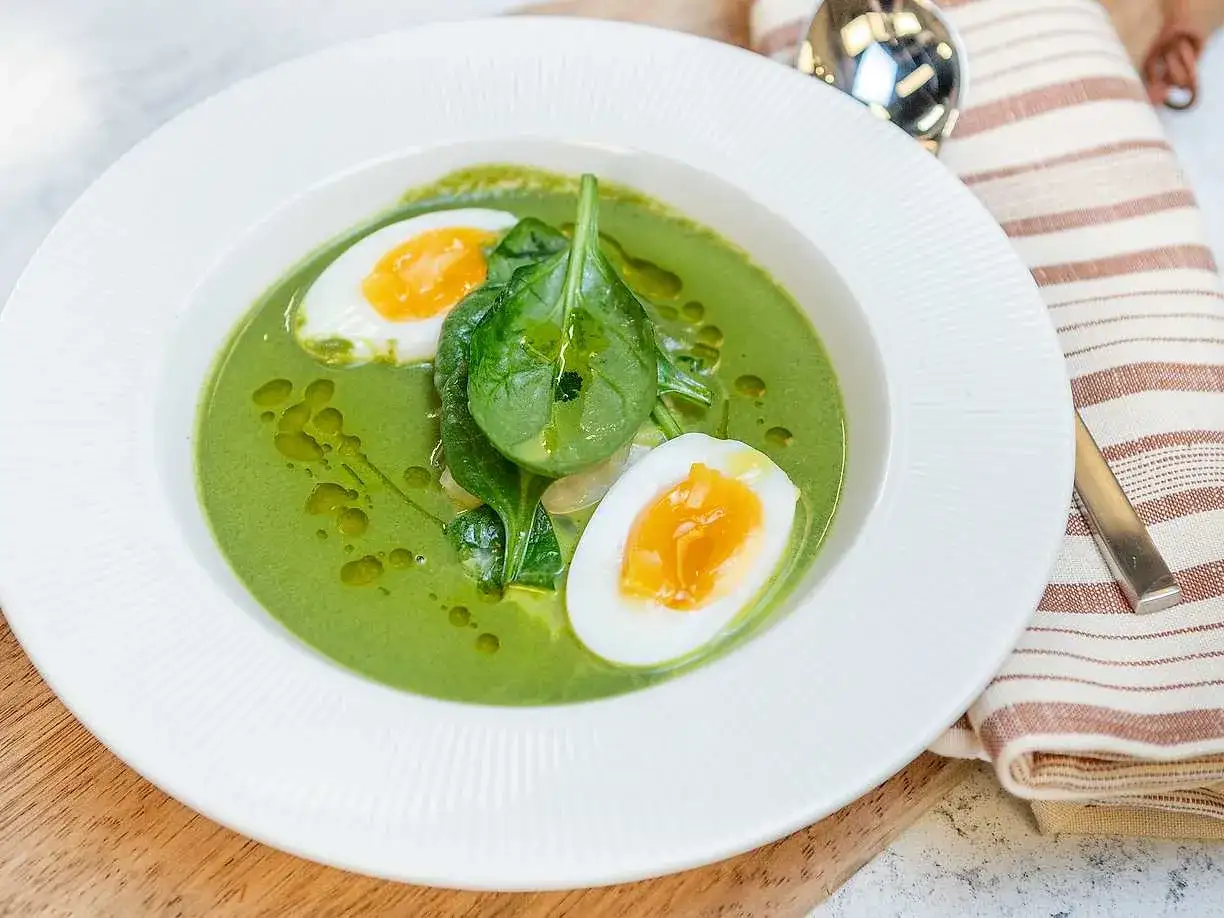 En krämig spenatsoppa med halverat kokt ägg och färska spenatblad. Ett enkelt och gott spenatsoppa recept.