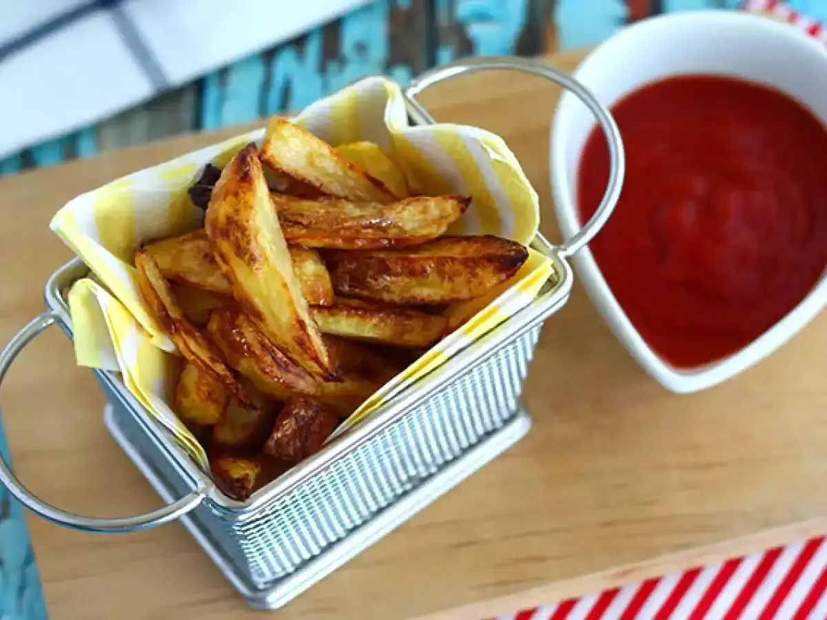 Krispiga pommes frites i en liten korg, redo att doppas i ketchup. Perfekt för en snabb fika.