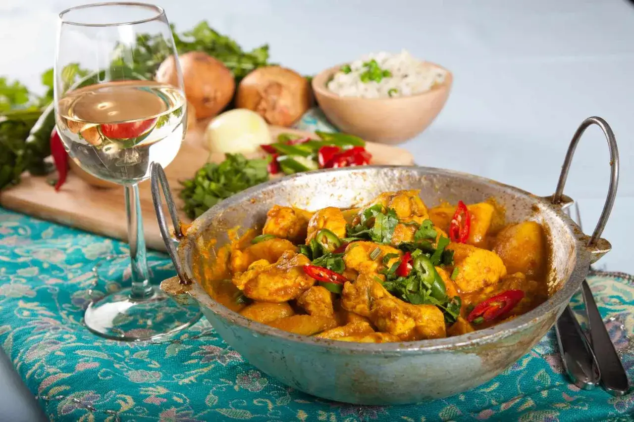 En smakrik kycklingcurry med ris, chili och koriander. Ett glas vitt vin till indisk mat är en perfekt kombination.