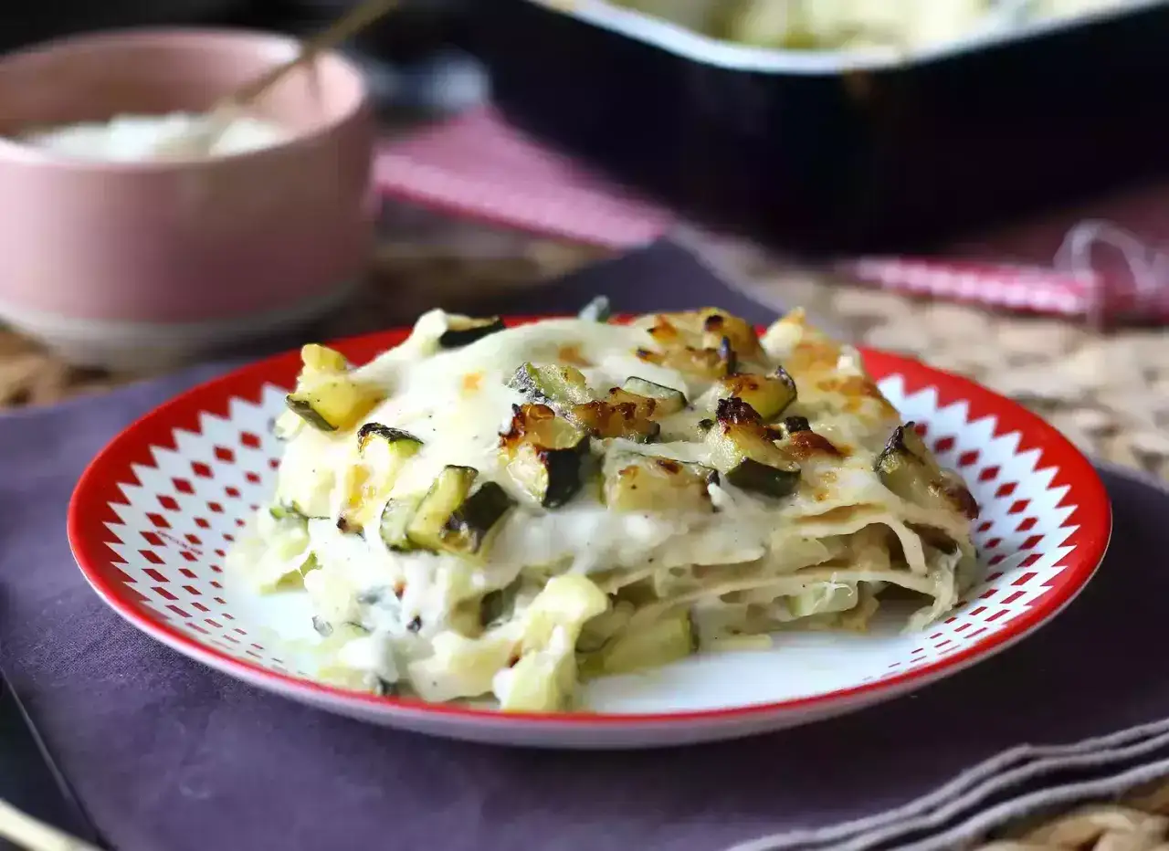En bit kr&auml;mig vegetarisk lasagne med zucchini, toppad med gyllene ost och gr&ouml;nsaker.