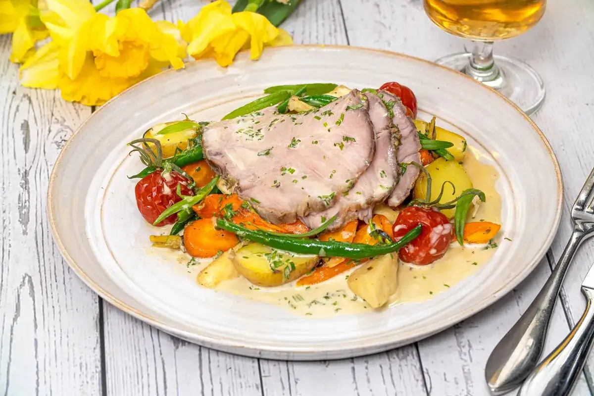 Skivad skinkstek med krämig sås, potatis, morötter, gröna bönor och tomater. Ett härligt skinkstek recept för en fin middag.