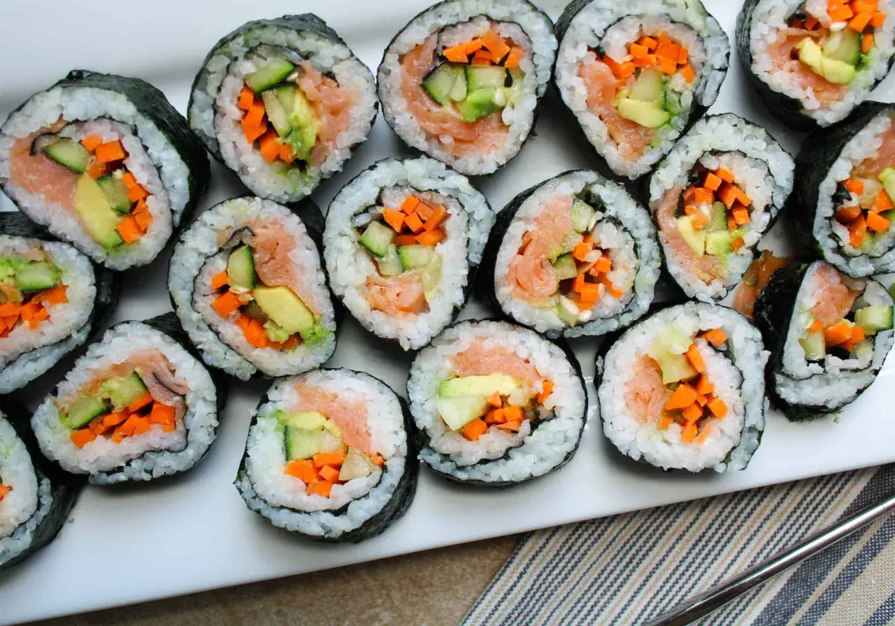 En tallrik med hemmagjord sushi, fylld med lax, gurka och morot. Perfekt för en mysig hemmakväll.