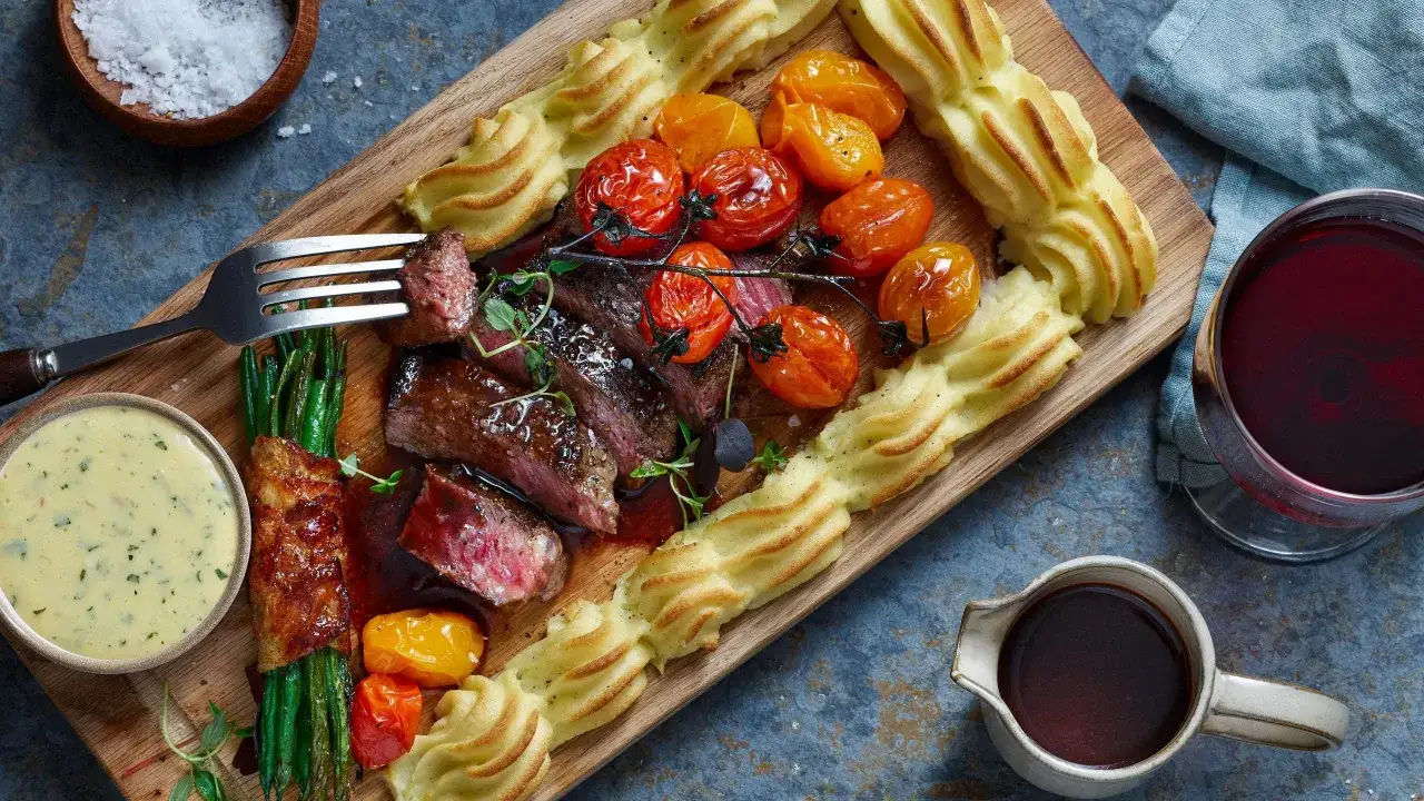 En saftig biff med potatismos, tomater och gröna bönor. Ett perfekt plankstek recept för en festmåltid.