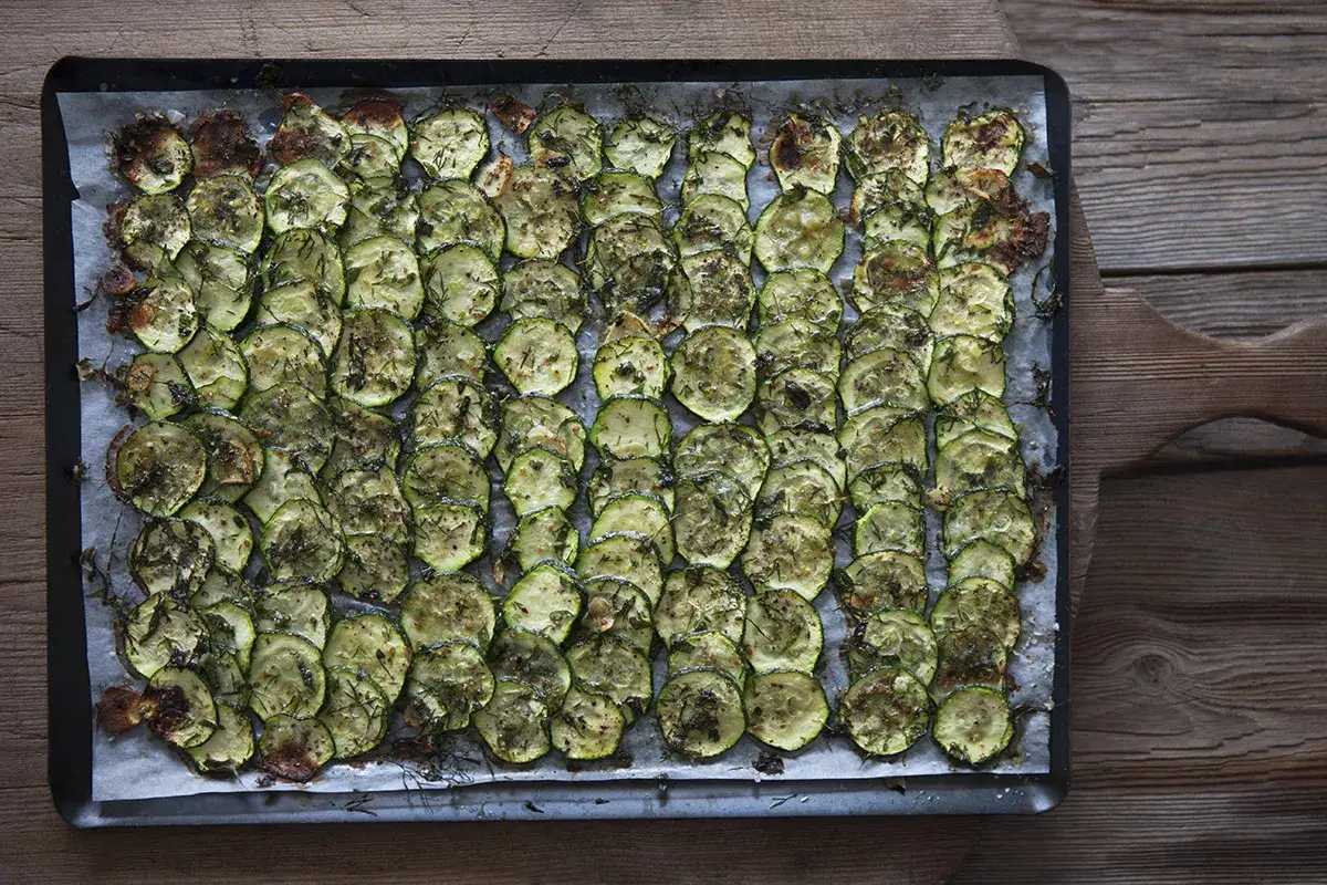 Ugnsbakade skivor av zucchini, kryddade med &ouml;rter och l&auml;tt rostade. Enkel och god r&auml;tt med zucchini i ugn.