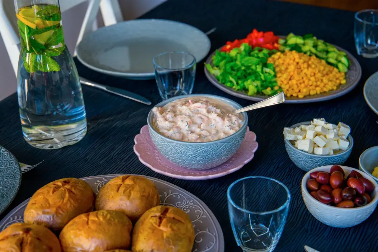 Perfekt bakad potatis i airfryer serveras med en krämig räkröra, fetaost, oliver och färska grönsaker. En festlig måltid!