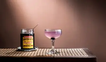 En elegant aviation drink med en burk Luxardo maraschino-körsbär, redo att förhöja smaken.