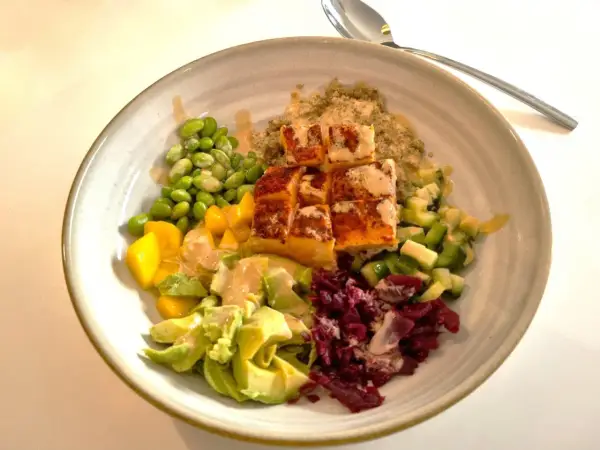 En vacker och hälsosam middagsbowl med lax, quinoa, edamamebönor, mango, avokado och rödbetor. Ett perfekt recept för en snabb och god middag.