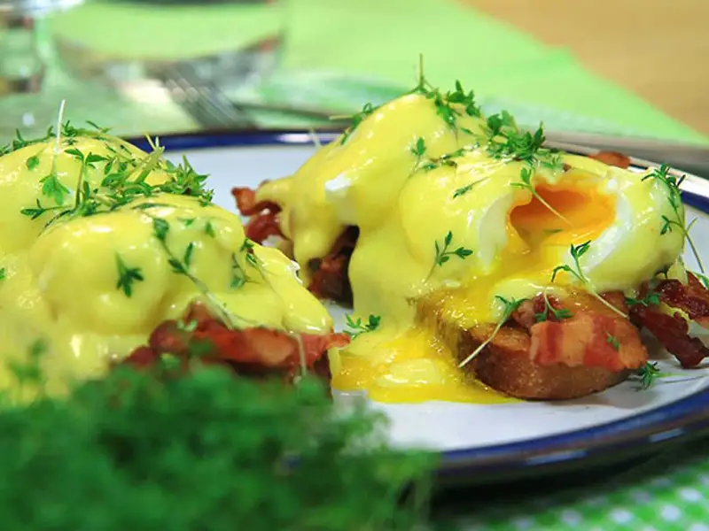 Läckra eggs benedict med krämig hollandaisesås, knaprigt bacon och färska örter. En perfekt start på dagen!