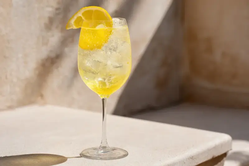 Ett glas med is och en citronskiva, perfekt för ett uppfriskande limoncello recept.