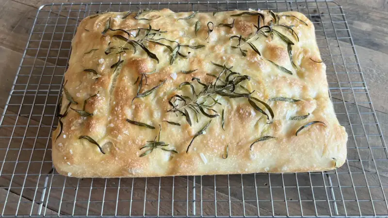 En gyllene, nybakad focaccia med rosmarin och flingsalt, perfekt för ditt nästa focaccia recept.