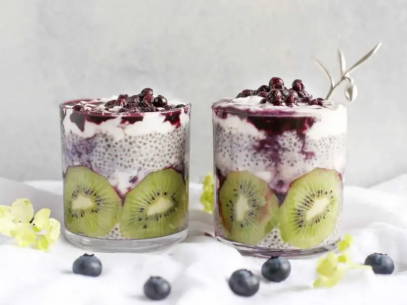 Två glas med chiapudding kvarg, kiwi och blåbär. En härlig frukost eller mellanmål.